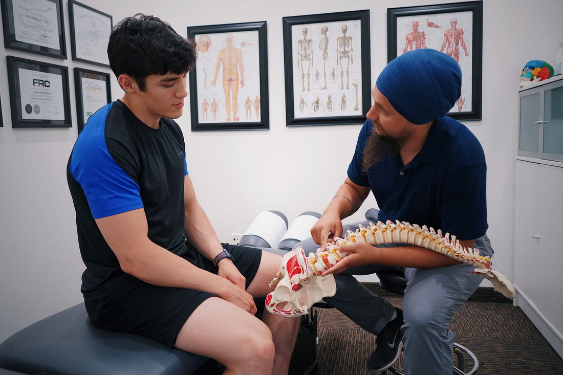 Chiropractor explaining the spine to a client with a spine model