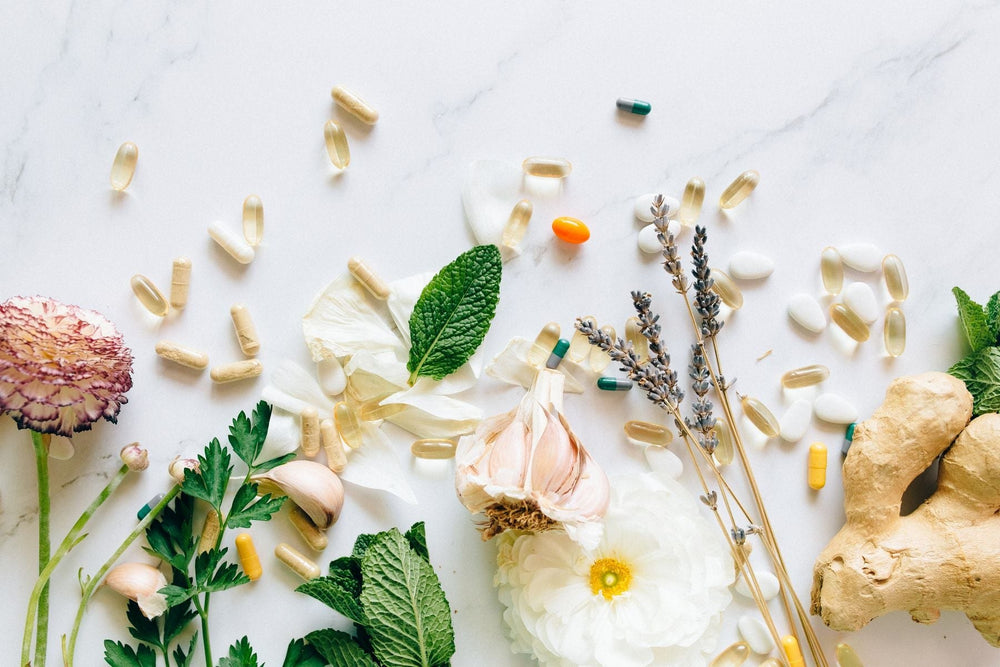 Herbs, flowers and supplements laid out on a marble surface